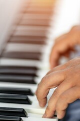 Obraz premium Close-up of hands playing piano keys with focus on fingers and musical expression