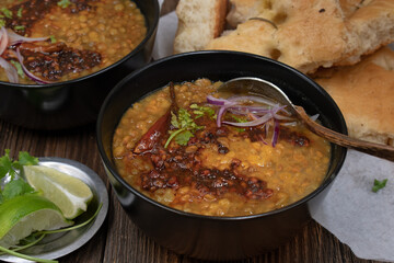 Vegan split green pea soup with tempered spices, flat breads on wooden table, copy space