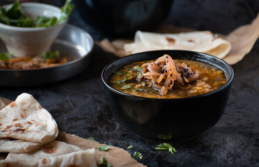 Vegan split yellow pea soup with caremelized onions, flat breads.  Black background, copy space