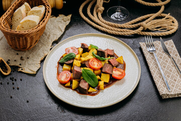 Gourmet beef cubes with roasted potatoes, cherry tomatoes and spinach with rich sauce and wine