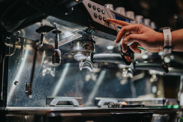 A baristas hand operates a professional espresso machine, preparing coffee in a vibrant cafe environment.
