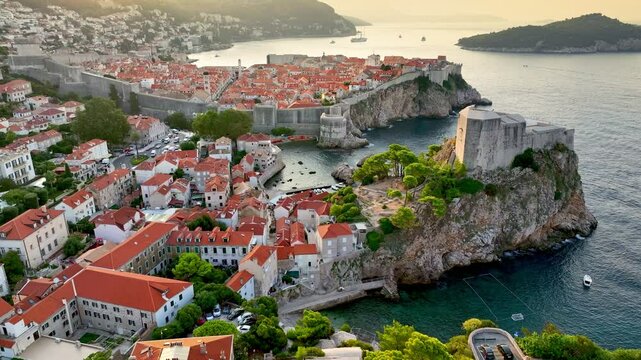 Lovrjenac Fortress, old town and orange tiled roofs of old buildings in Dubrovnik, Croatia - famous tourist attraction in Mediterranean. Aerial shot of Dubrovnik city at sunrise 