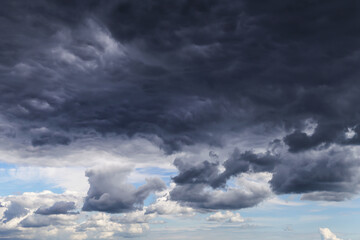 Obraz premium Storm dark grey cumulus rain clouds against blue sky background texture, thunderstorm