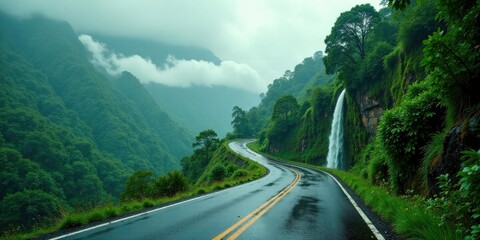 Serene Winding Road Beside a Lush Waterfall in a Misty Mountain Valley