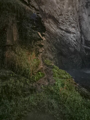 Rocky cliffs near aosta embracing verdant foliage, highlighting alpine landscape's lush greenery during late autumn's peaceful moments Isollaz waterfall