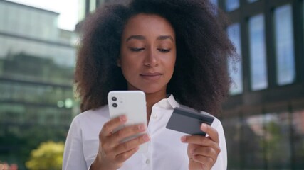 African American woman using mobile phone smartphone bank card online pay internet app finance money female businesswoman buying order shopping business city outside girl technology debit cash credit