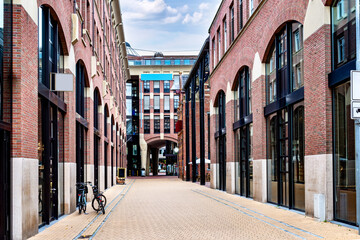 A perspective view of Waagstraat in Groningen, featuring modern brick architecture with arched windows and storefronts. Netherlands © EKH-Pictures