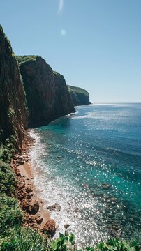 Coastal cliffs meet turquoise ocean, vibrant scenery, scenic vista, perfect for travel or nature backgrounds