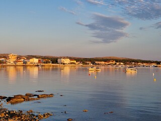 Coastal village with boats on calm water at sunset