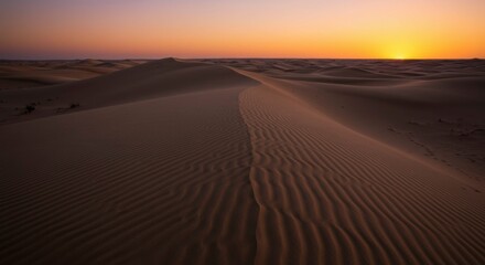 Serene sunset over vast desert dunes, showcasing rippled sand patterns and tranquil atmosphere