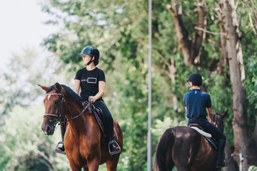 Two riders enjoy horseback riding through a scenic forest. The serene environment is perfect for equestrian training and relaxation amidst nature's beauty.