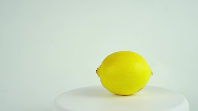 Yellow lemon rotating close-up on a white background