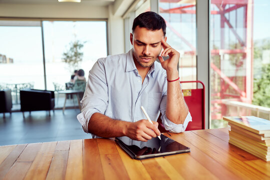 Focused man using a tablet in a bright, contemporary workspace