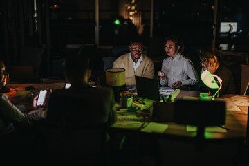 A group of multicultural colleagues working late at night, collaborating on projects. The scene captures teamwork, dedication, and focus, highlighting a diverse and dynamic business environment.