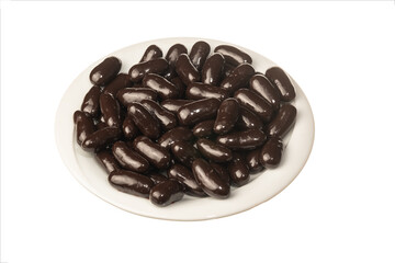 Brown dragee in white plate isolated on a white background. Close up shot. Ramadan candy concept idea