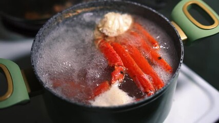 slow motion crab claws submerged in boiling water inside a green pot, showcasing the cooking process of fresh seafood. Ideal for culinary, food preparation, and seafood-themed content