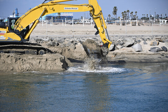 HUNTINGTON BEACH, CALIFORNIA: 29 JAN 2025: Workers Dredging the mouth of the Santa Ana River to replace sand on eroded beaches.