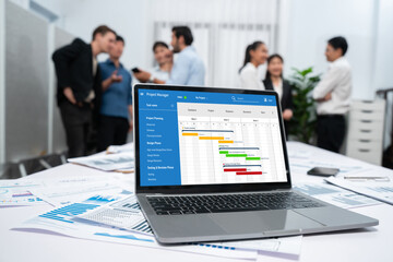 Project planning software for brisk business project management on the computer screen showing timeline chart of the team project
