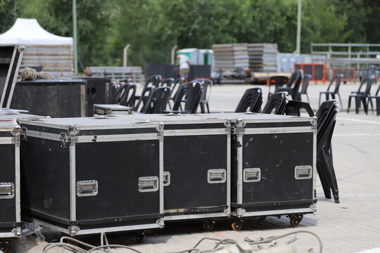 Equipment crates stacked backstage at a live music event during daytime preparations for an outdoor concert	
