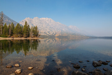 Scenic Mountain Lake Landscape with Forest Reflection and Golden Autumn Vegetation

