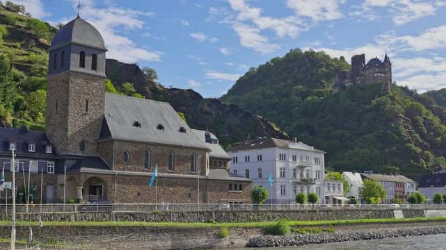 Small medieval village on the banks of the Rhine River with a towering castle on the surrounding hilltop, Sankt Goarshausen, Germany
