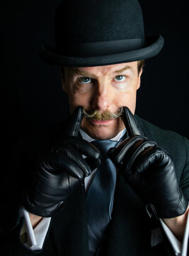 Gentleman in Dark Formal Suit and Bowler Hat and Leather Gloves With a Moustache. Vintage Style and Retro Fashion.