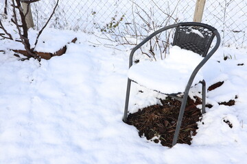 A Lonely Chair Covered in Fresh Snow, Set Against a Winter Landscape of Stillness