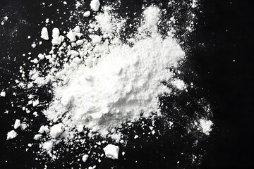 White powder scattered over black background