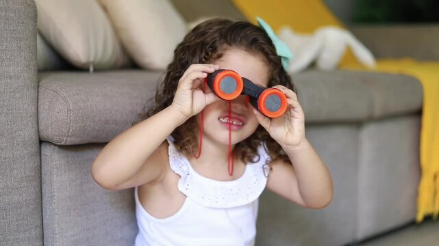 menina brincando com bin&oacute;culo 