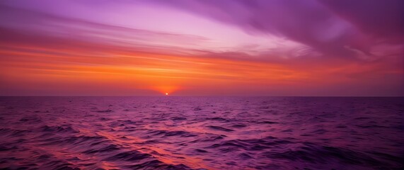 Fototapeta premium Captivating Image of a Sunset Over a Calm Ocean The Sky a Palette of Deep Orange Pink and Purple Melting into Silky Waters Below