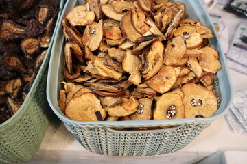 Dried slices of apples neatly arranged in a charming market basket ready for sale