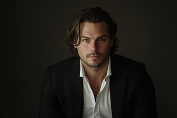 Confident Young Man in Formal Attire Against Dark Background