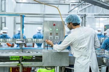 scientist food processing plant supervisor examines industrial control systems, overseeing the production line to maintain high-quality standards and optimize the automated manufacturing process.