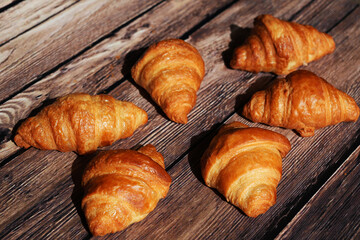 Golden Croissants on Rustic Wooden Surface