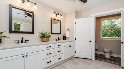 Stylish double vanity bathroom features chrome fixtures, black mirrors, and natural light illuminating the spacious area
