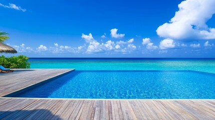 Serene Blue Swimming Pool with Teak Wood Flooring - A tranquil view of an infinity pool with bright blue water, surrounded by lush greenery and a vast ocean under a sunny sky, symbolizing relaxation
