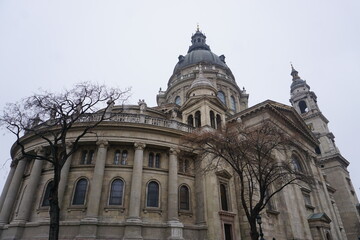View of the ornate backside of St. Stephen's Basilica in Budapest, Hungary with its famous church dome, historic statues, and columns