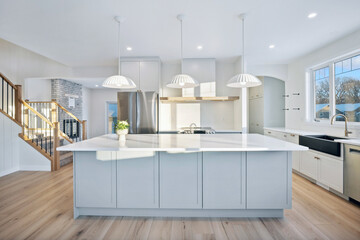 Large white kitchen with a white island and a sink