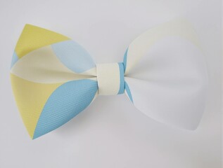 A yellow and blue striped bow tie is tied in a knot