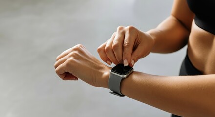 A woman is wearing a smart watch and is adjusting it