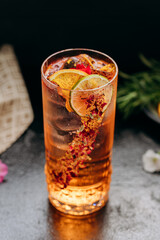 Refreshing floral cocktail with dried lime and petal garnish in an elegant glass, perfect for events