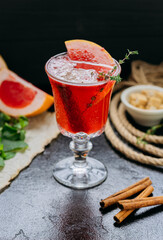 Refreshing grapefruit cocktail with herbs and cinnamon in elegant glass, perfect for summer evenings