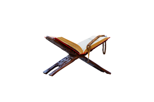 A close-up shot of an open Quran on a traditional wooden stand  with a string of prayer beads laid on top. The image is set against a plain png background, highlighting the Quran and prayer