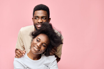 Obraz premium A joyful couple posing together against a pink background, showcasing love and happiness with vibrant outfits and expressive emotions