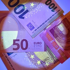 Checking banknotes with ultraviolet. Euro currency protected from ultraviolet radiation. Euro in...