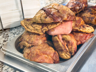 Close-up of freshly cooked traditional chicharrón pieces on stainless steel tray