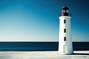 Fototapeta premium Lonely Lighthouse Standing Strong Against the Vast Ocean Under a Serene Blue Sky