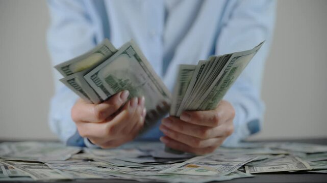 Female hands counting one hundred dollar bills and passing stock to man hand. Close up