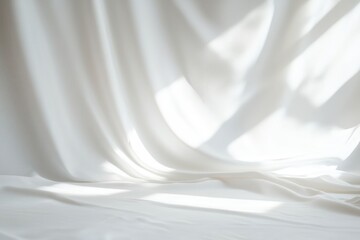 Elegant white fabric draped with soft light and gentle shadows creating a serene and minimalist atmosphere, perfect for backgrounds or designs