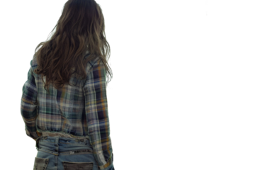 A woman with long hair is wearing a plaid shirt and jeans